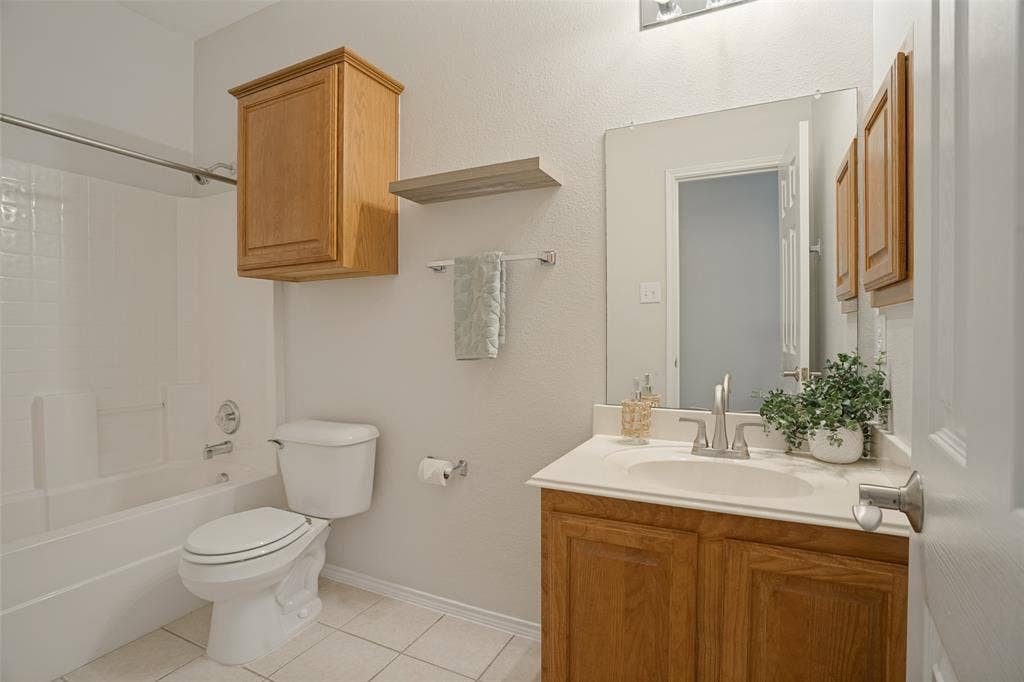 Secondary full bathroom with tub-shower combination and storage