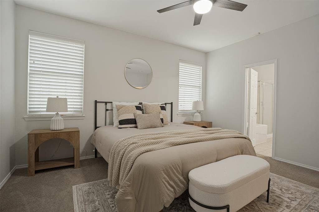 Primary bedroom with neutral finishes and ceiling fan