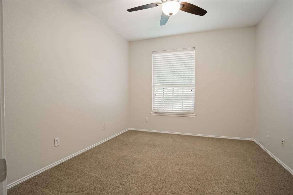 Secondary bedroom with neutral carpeting and natural light