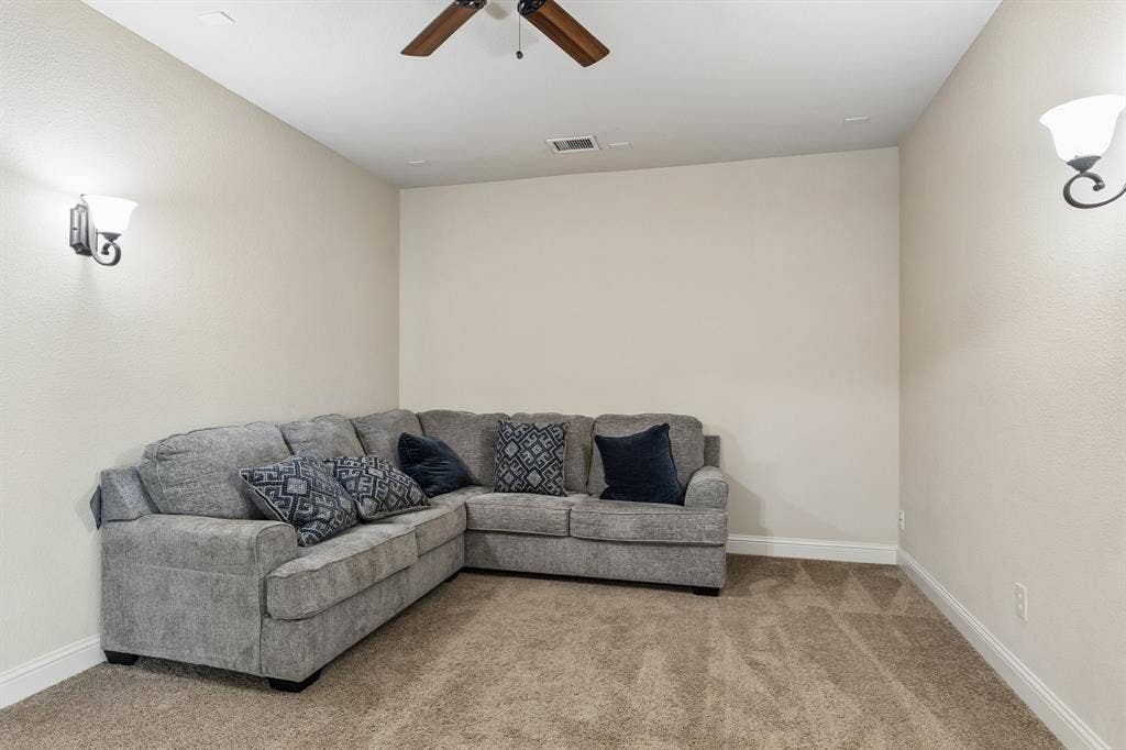 6448 Fire Creek Trail, Frisco, TX 75036 Neutral wall tones, plush wall-to-wall carpeting, ceiling fan with light fixture, and dual wall-mounted sconces