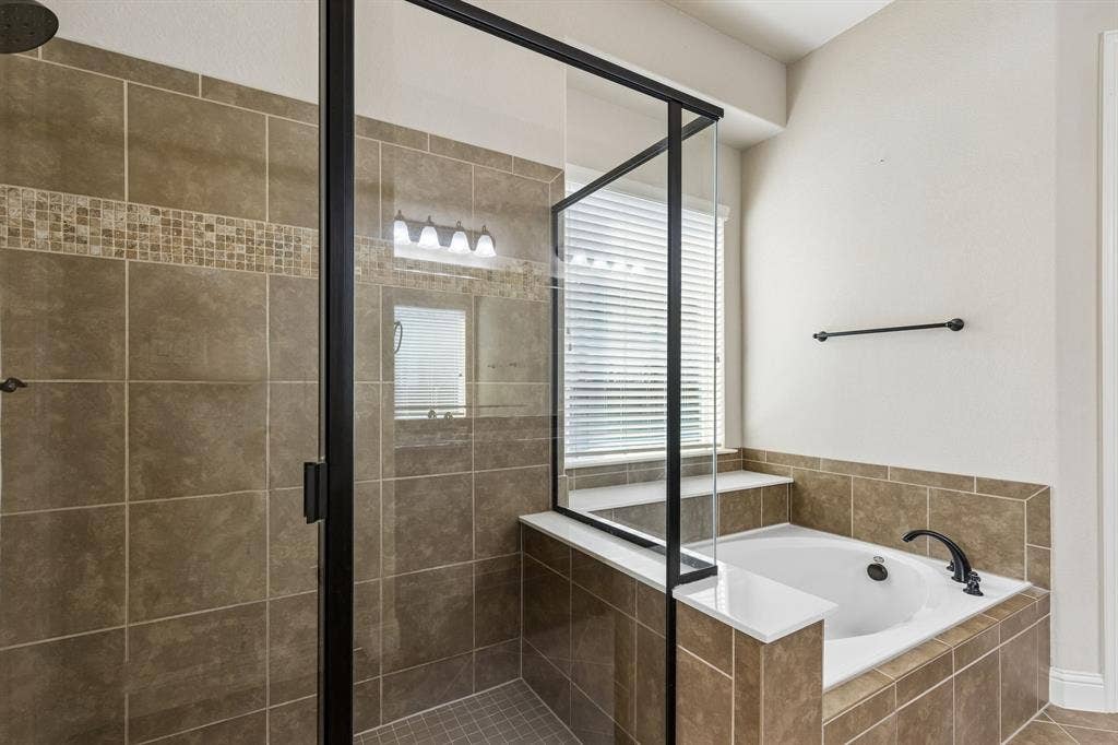 6448 Fire Creek Trail, Frisco, TX 75036 Walk-in shower with matte black frame and tile surround, built-in soaking tub with tile deck, and mosaic tile accent detailing
