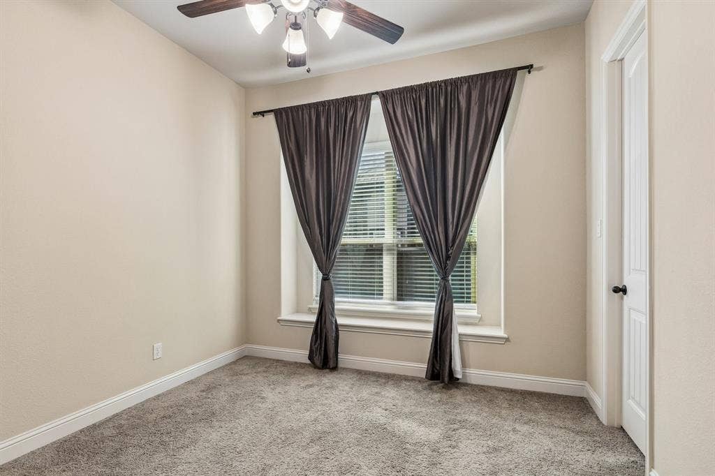 6448 Fire Creek Trail, Frisco, TX 75036 Neutral-toned interior featuring wall-to-wall carpeting, a recessed window with a built-in sill, a ceiling fan with integrated lighting, and a paneled interior door