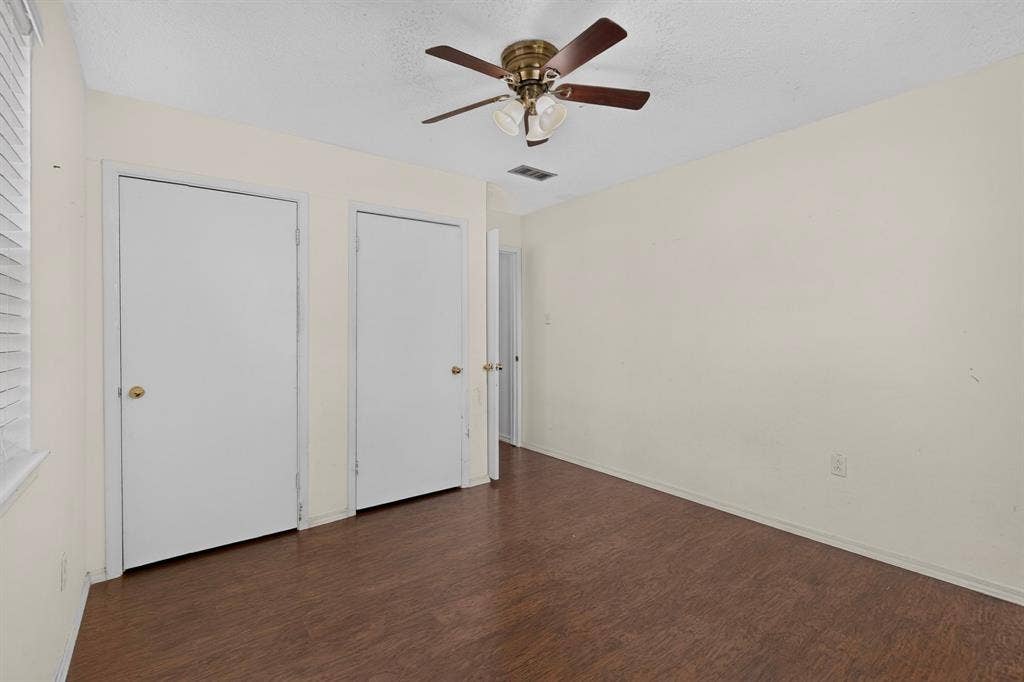 9651 Cherry Street, Frisco, TX 75033 Room featuring wood-finish flooring, two sets of solid-core doors, and a ceiling-mounted light fixture with a fan