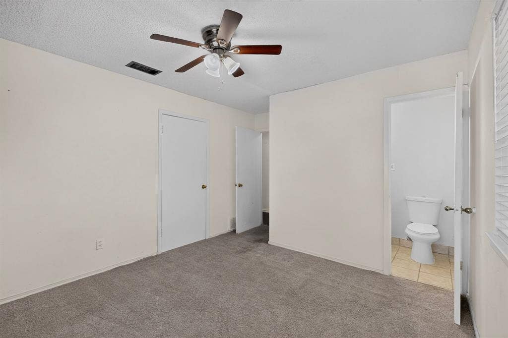 9651 Cherry Street, Frisco, TX 75033 Interior space featuring neutral wall tones, wall-to-wall carpeting, ceiling fan with integrated lighting, and a private restroom with tile flooring
