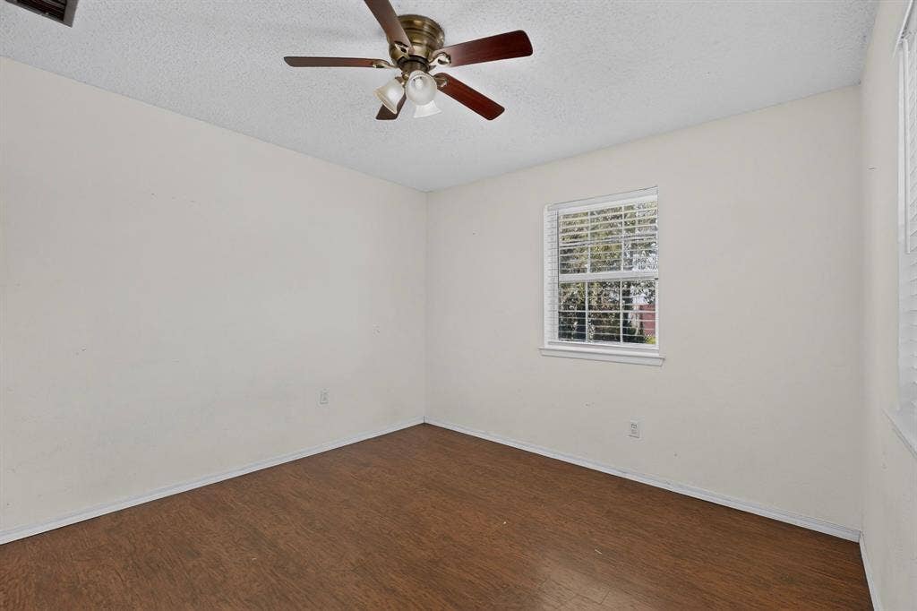 9651 Cherry Street, Frisco, TX 75033 Room featuring wood-finish flooring, a multi-blade ceiling fan with integrated lighting, and a window with horizontal blinds