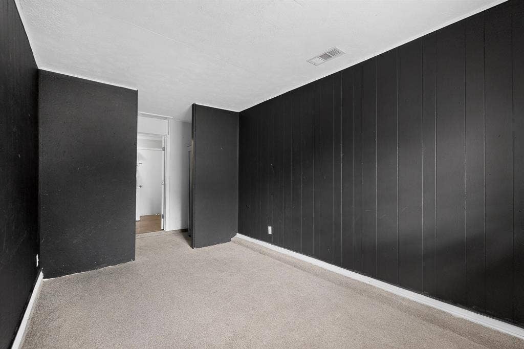 9651 Cherry Street, Frisco, TX 75033 Interior space featuring vertical wood-paneled walls finished in matte black and neutral-toned wall-to-wall carpeting
