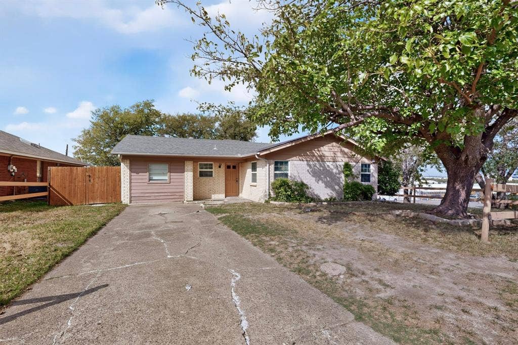 9651 Cherry Street, Frisco, TX 75033 Single-story residence featuring light-colored masonry, horizontal siding, a concrete driveway, and a wooden perimeter fence