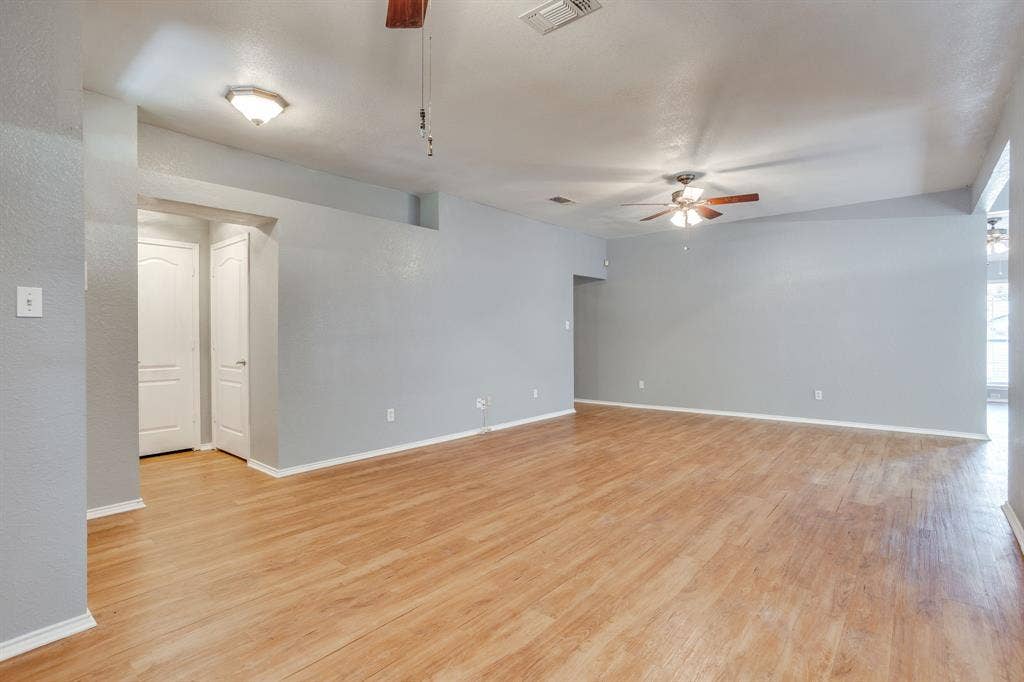6221 St Leonard Drive, Arlington, TX 76001 Open-concept interior featuring wood-finish flooring, dual ceiling fans, flush-mount lighting, and solid-core interior doors