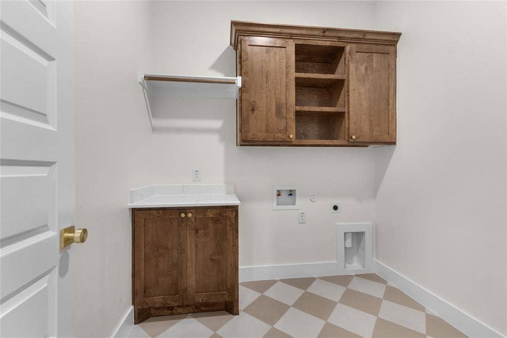 Stained wood cabinetry with crown molding, white countertop surface, white wall-mounted shelf, and checkerboard patterned flooring