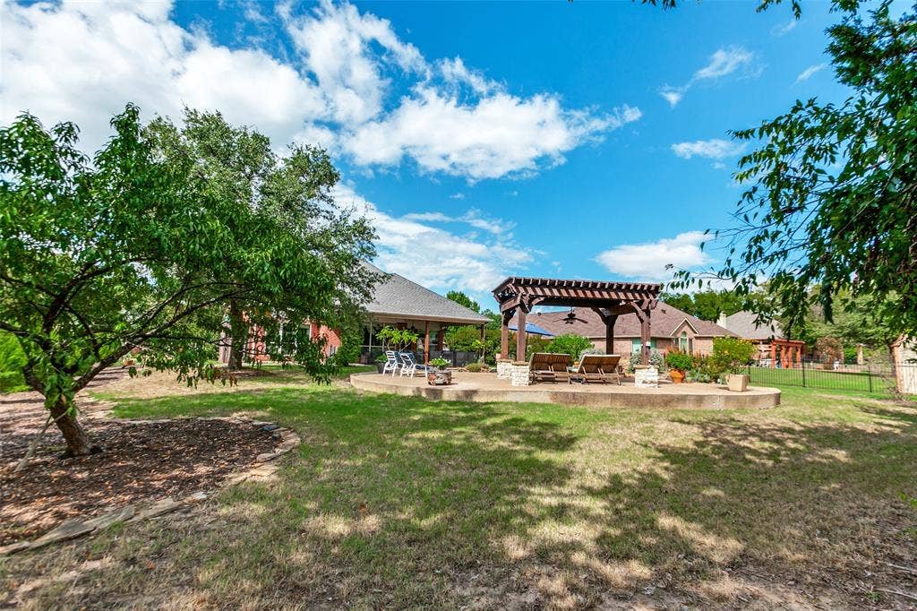 214 Stanford Ct. - Expansive backyard view showcasing the spacious lawn, rear of the pergola, and back of the home.