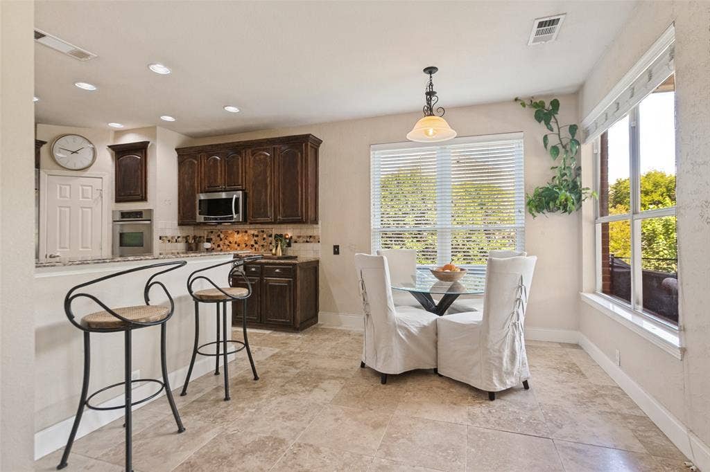 214 Stanford Ct. - Bright breakfast area with convenient counter seating and views of the patio and pool.