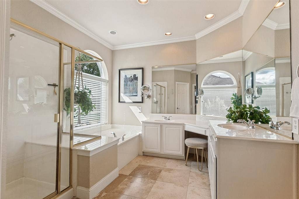 214 Stanford Ct. - Primary en-suite featuring travertine flooring, dual vanities, large mirror, garden tub, separate shower with built-in seat, and recessed lighting.