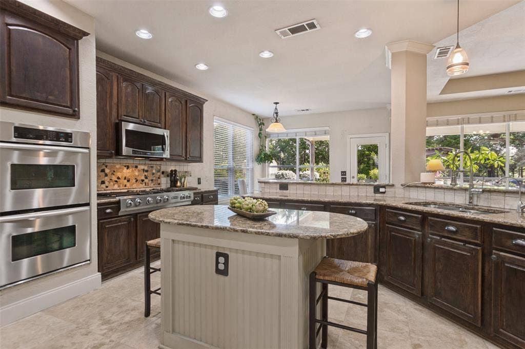 214 Stanford Ct. -kitchen featuring granite countertops, center island, double ovens, built-in microwave, gas range, built-in refrigerator, and walk-in pantry.