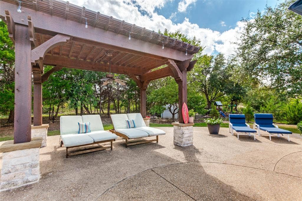 214 Stanford Ct. - Pergola overlooking the pool, featuring a ceiling fan and lighting for comfortable outdoor enjoyment.