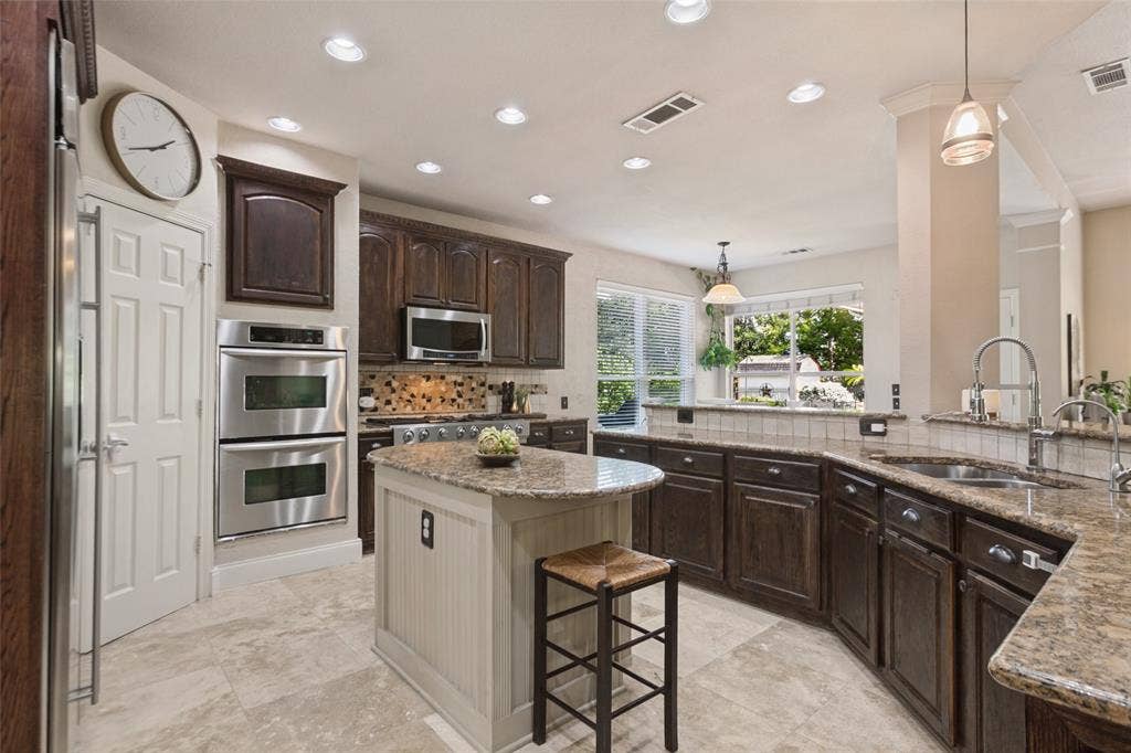 214 Stanford Ct. - kitchen featuring granite countertops, center island, double ovens, built-in microwave, gas range, built-in refrigerator, and walk-in pantry.