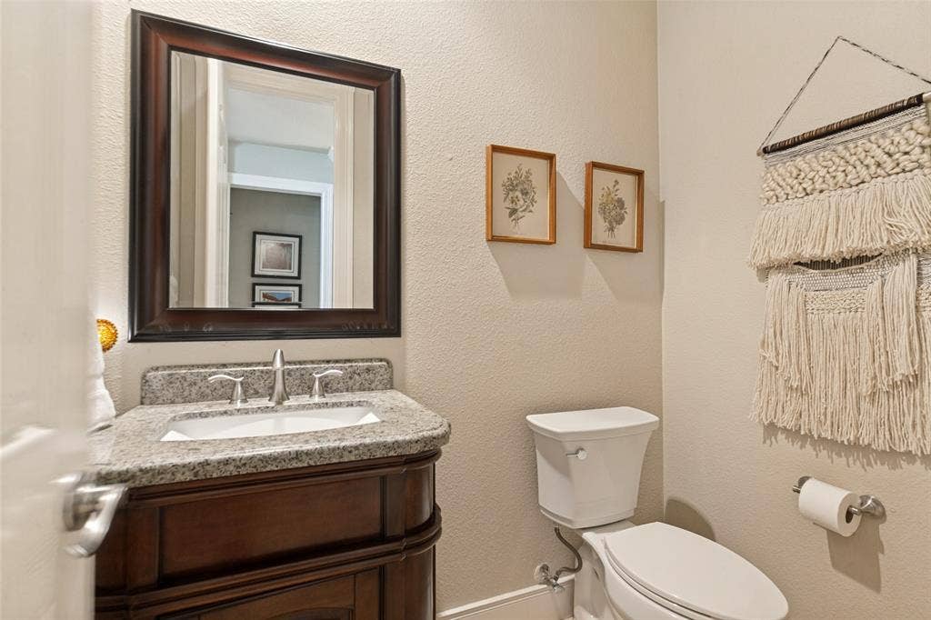 214 Stanford Ct. - First-floor powder room featuring a decorative vanity and granite countertop.