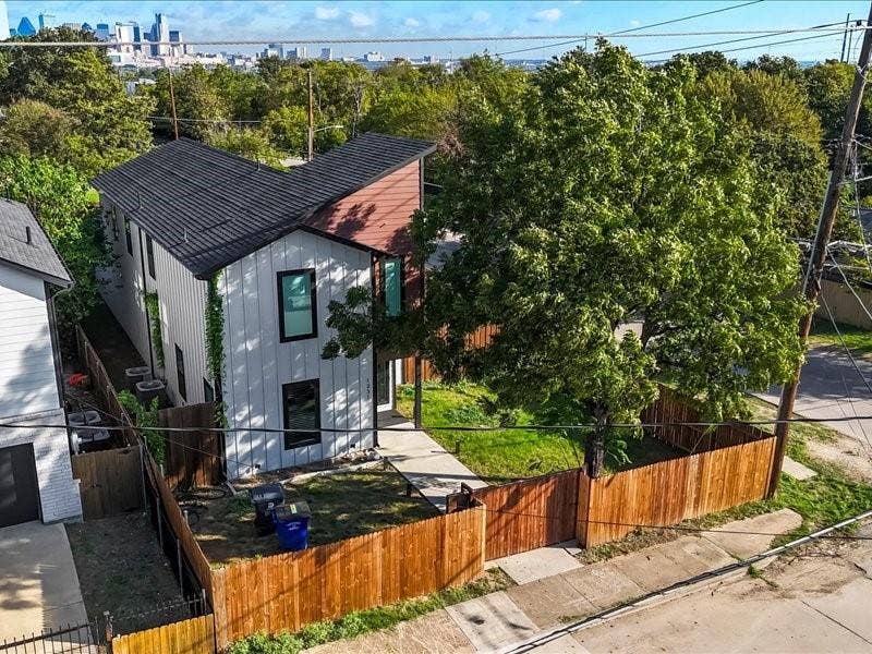 Modern two-story exterior featuring vertical metal siding, an asymmetrical roofline, and wood-paneled accents