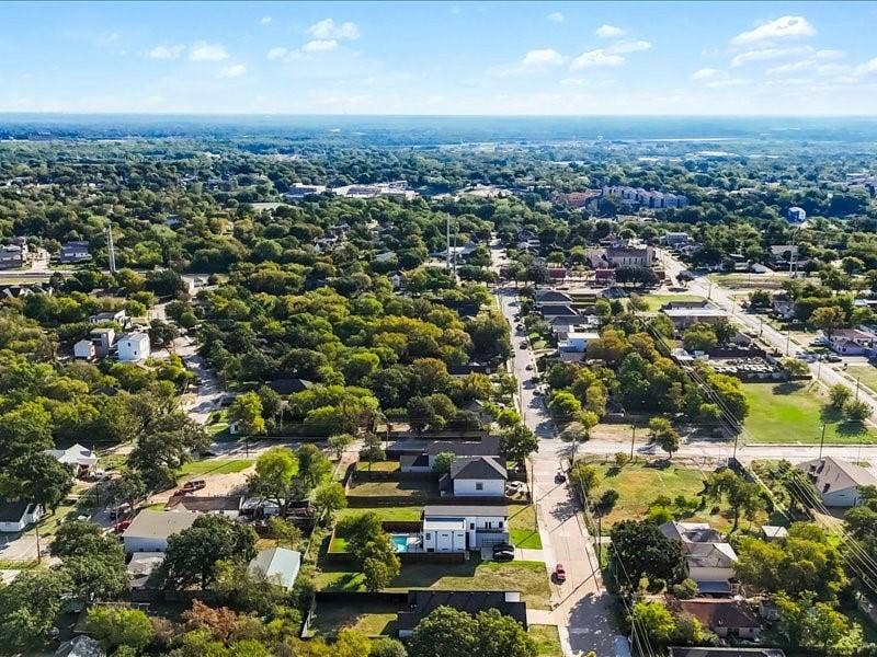 Aerial perspective featuring a residential lot with a backyard swimming pool and mature tree canopy