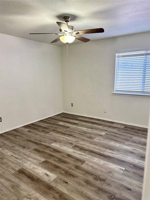 9756 Old Field Drive, McKinney, TX 75072 Wood-finish flooring, neutral walls, brushed metal ceiling fan with integrated light fixture, and horizontal window blinds