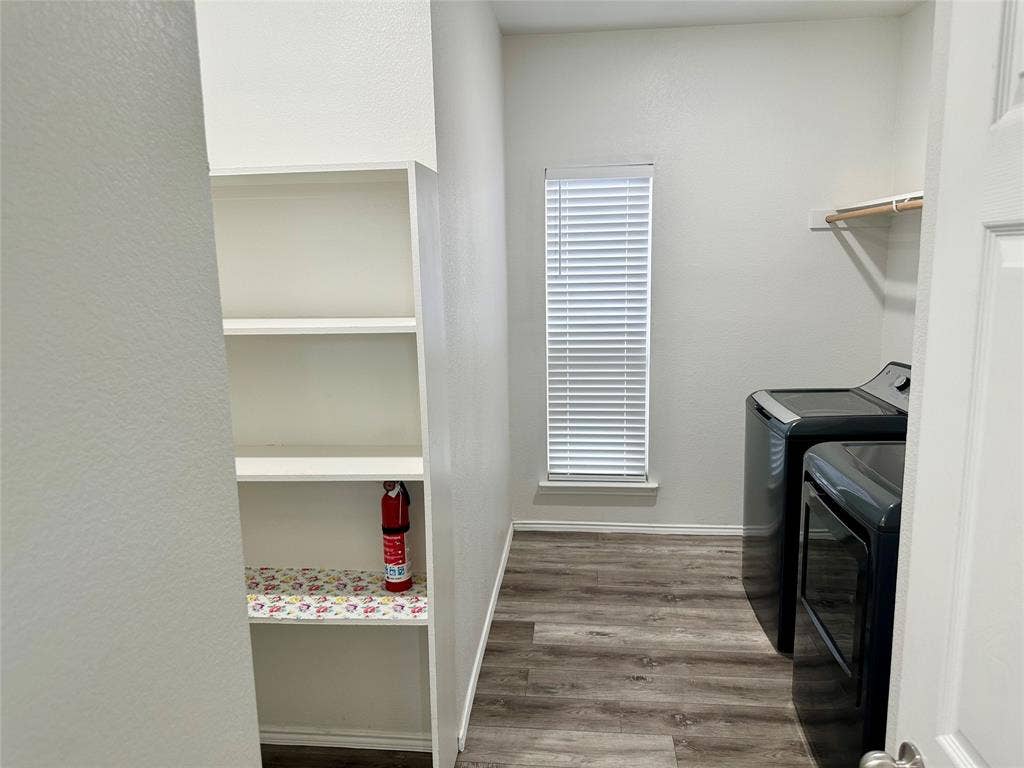 9756 Old Field Drive, McKinney, TX 75072 Utility space featuring wood-finish flooring, built-in shelving, a window with horizontal blinds, and a mounted hanging rod