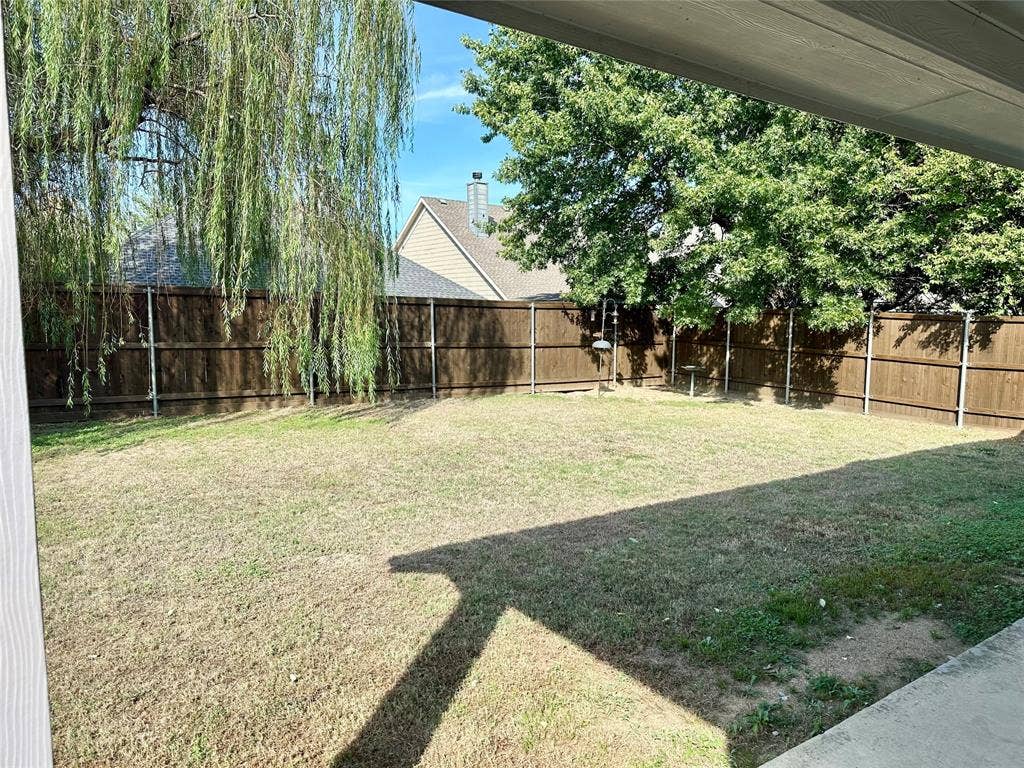 9756 Old Field Drive, McKinney, TX 75072 Private backyard featuring a concrete patio, perimeter wood privacy fencing, a grass lawn, and mature canopy trees