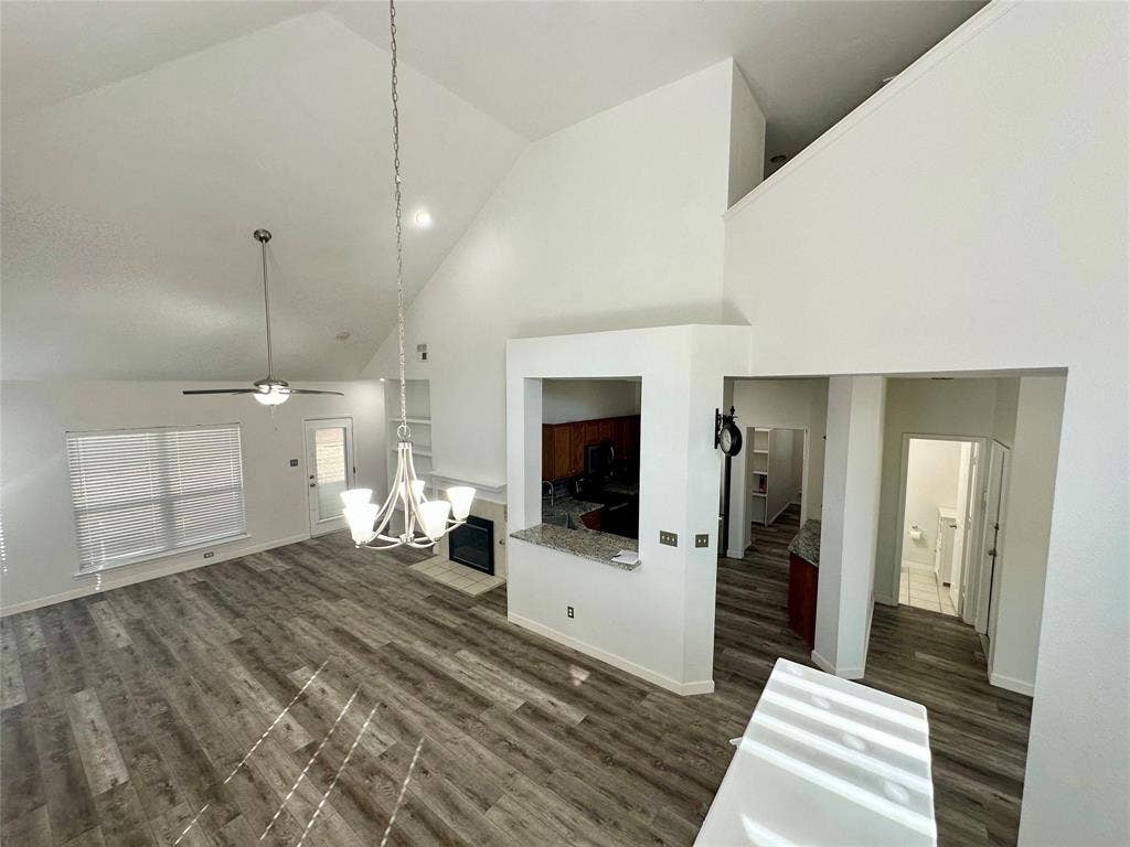 9756 Old Field Drive, McKinney, TX 75072 Vaulted ceilings, wood-finish flooring, built-in fireplace, and overhead lighting fixtures