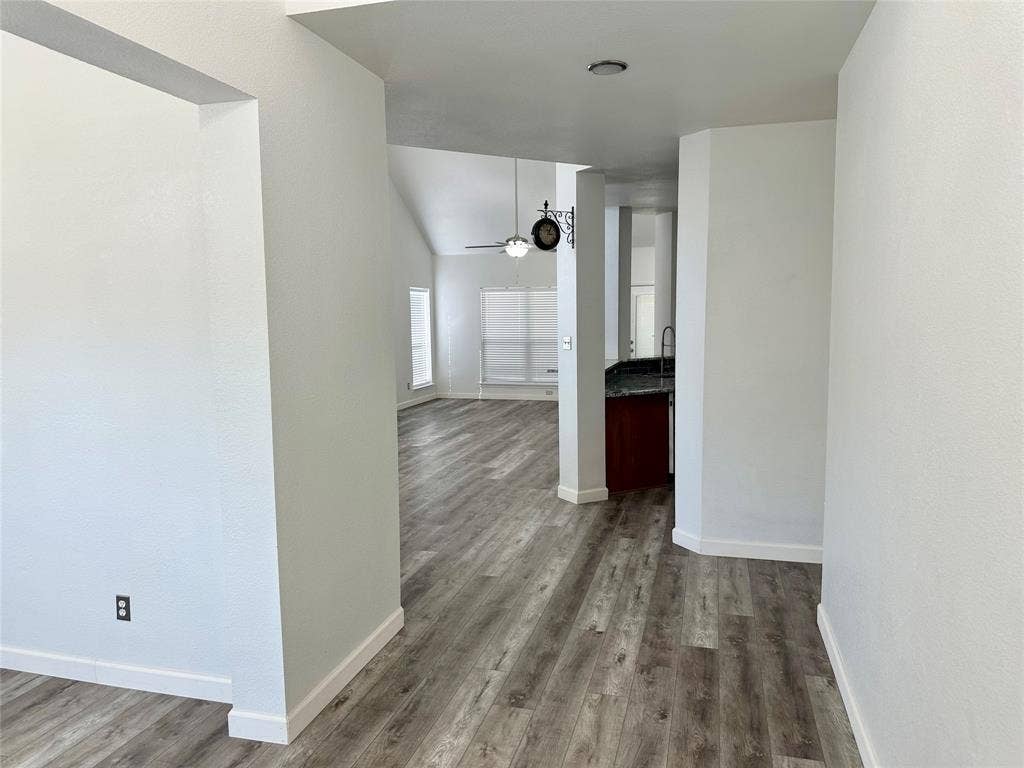 9756 Old Field Drive, McKinney, TX 75072 Wood-finish flooring, vaulted ceilings, and kitchen cabinetry with stone-finish countertops