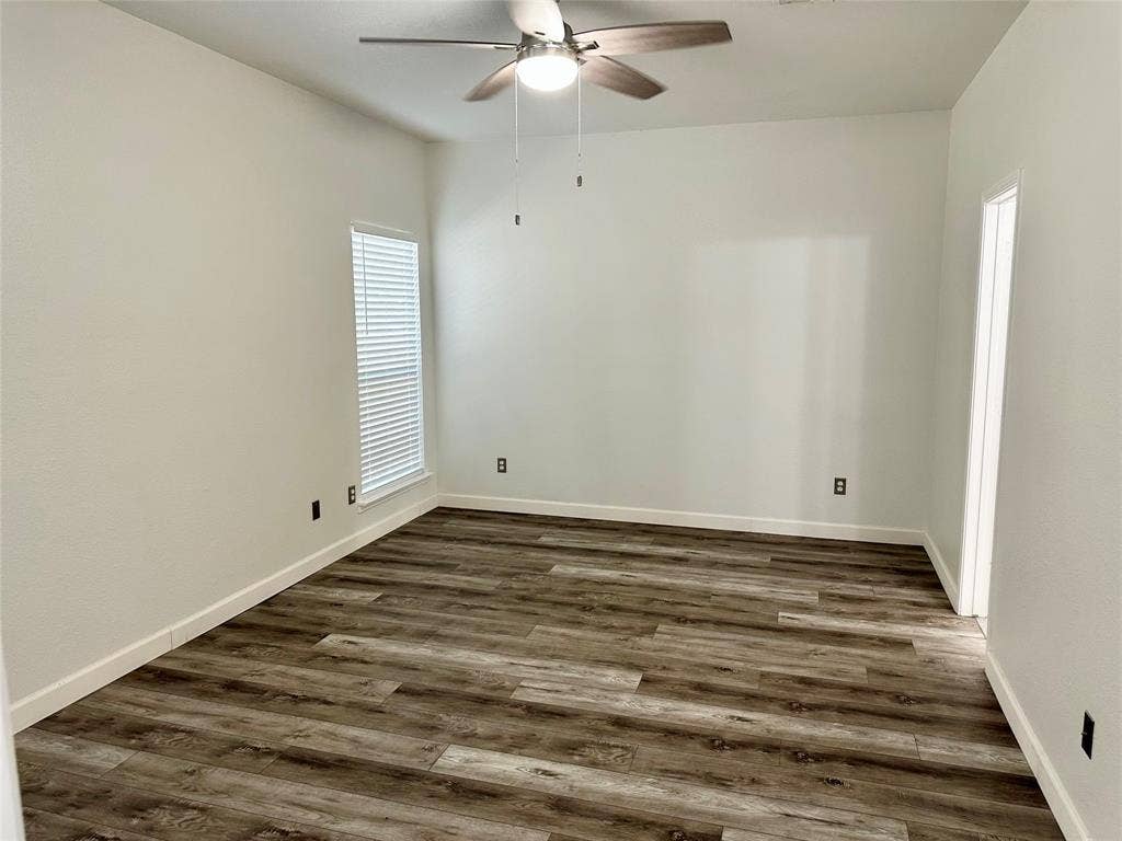 9756 Old Field Drive, McKinney, TX 75072 Neutral-toned interior space featuring wood-finish flooring, a ceiling fan with integrated light fixture, and horizontal blind window treatments
