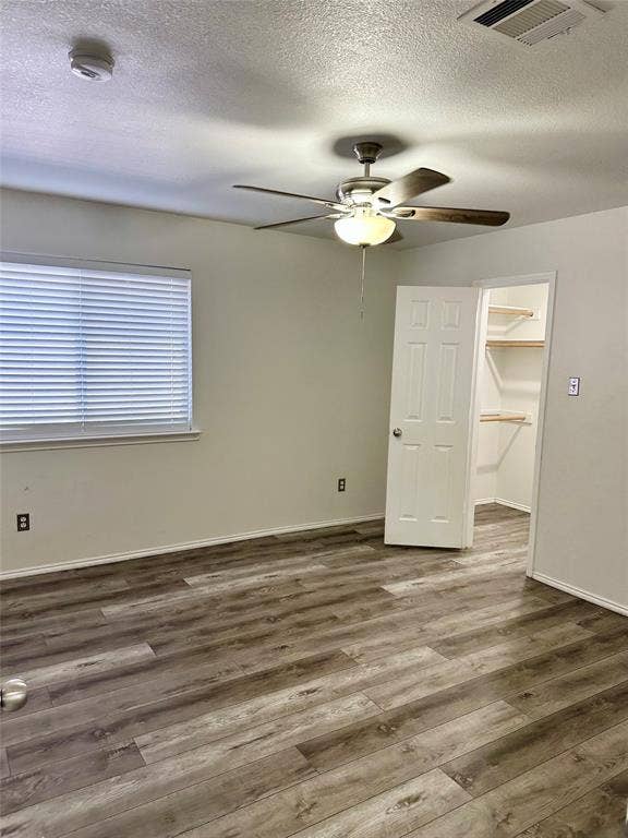 9756 Old Field Drive, McKinney, TX 75072 Wood-finish flooring, ceiling fan with integrated light fixture, window with horizontal blinds, and walk-in closet with built-in shelving