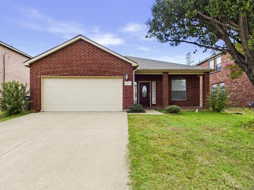 12652 Oakwood Circle, Fort Worth, TX 76040 Single-story brick exterior featuring a covered front porch, arched entryway, two-car garage, and concrete driveway