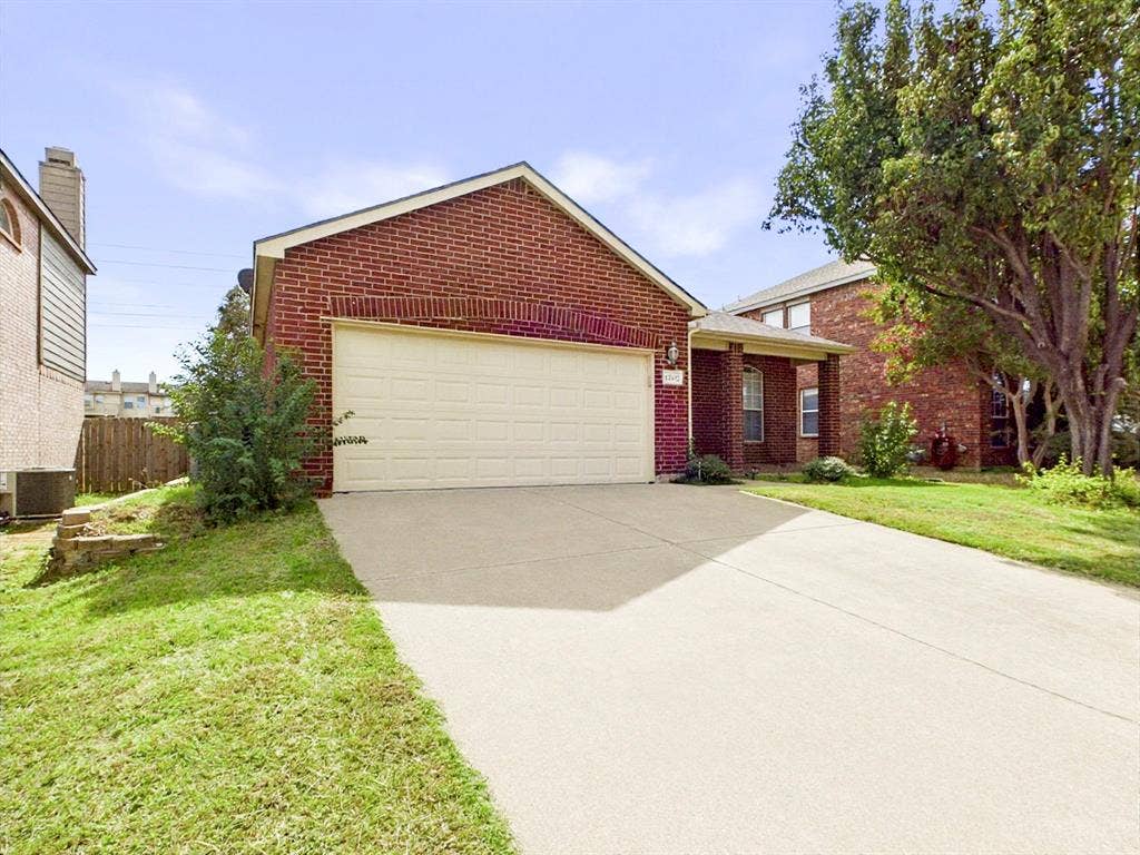 12652 Oakwood Circle, Fort Worth, TX 76040 Brick exterior with attached two-car garage, concrete driveway, and front lawn