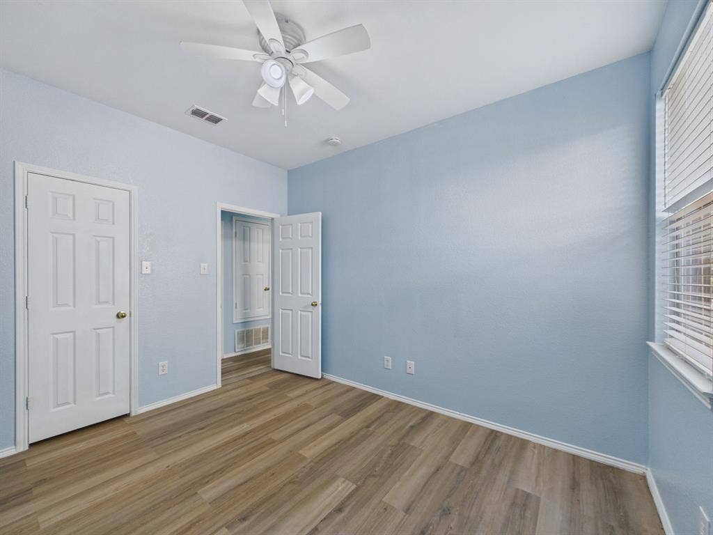 12652 Oakwood Circle, Fort Worth, TX 76040 Room featuring wood-finish flooring, white six-panel interior doors, and a ceiling fan with integrated lighting