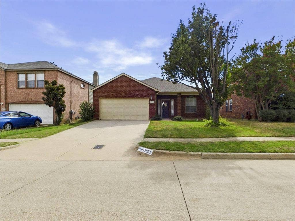 12652 Oakwood Circle, Fort Worth, TX 76040 Single-story brick exterior featuring an attached two-car garage, concrete driveway, and front lawn
