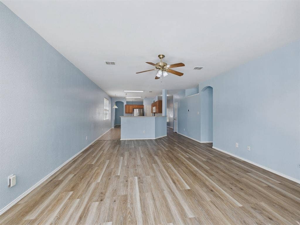 12652 Oakwood Circle, Fort Worth, TX 76040 Open-concept interior featuring wood-finish flooring, a central ceiling fan with integrated lighting, recessed lighting, and a breakfast bar