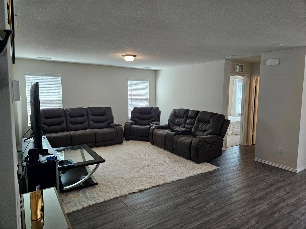 1860 Ballinger Drive, Forney, TX 75126 Living area featuring wood-finish flooring, two dual-pane windows with horizontal blinds, and a neutral color palette