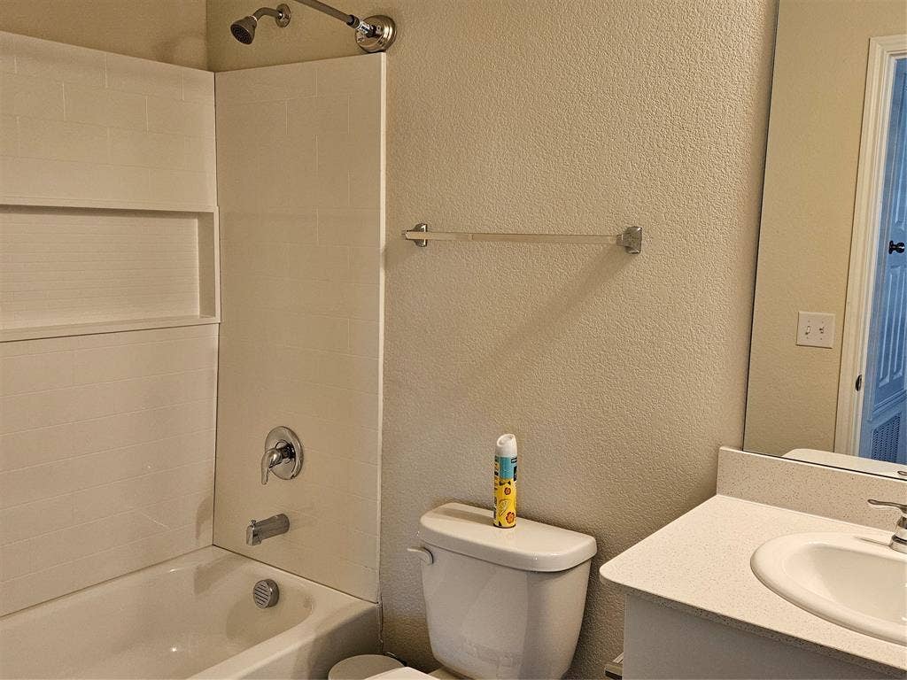 1860 Ballinger Drive, Forney, TX 75126 Bathroom featuring a shower and tub combination with built-in shelving, chrome fixtures, a wall-mounted towel bar, and a vanity with an integrated basin