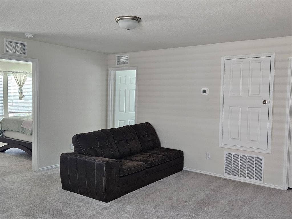 1860 Ballinger Drive, Forney, TX 75126 Interior room featuring neutral wall-to-wall carpeting, white interior doors, and a built-in wall access panel