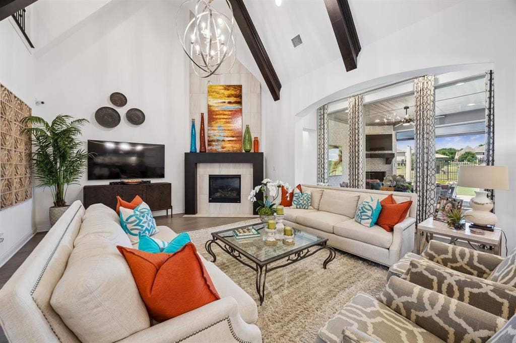 641 Country Brook Lane, Prosper, TX 75078 Oversized heart of the home family room with soaring beamed ceiling, stunning chandelier, and floor to ceiling fireplace all looking out to lake, fountain and greenbelt.