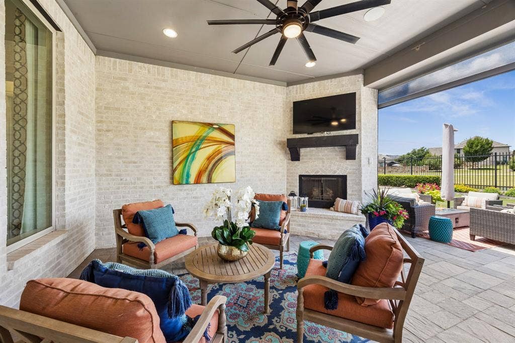 641 Country Brook Lane, Prosper, TX 75078 Covered back paito with fireplace and electric sun screens make this the ideal exterior space all year long.