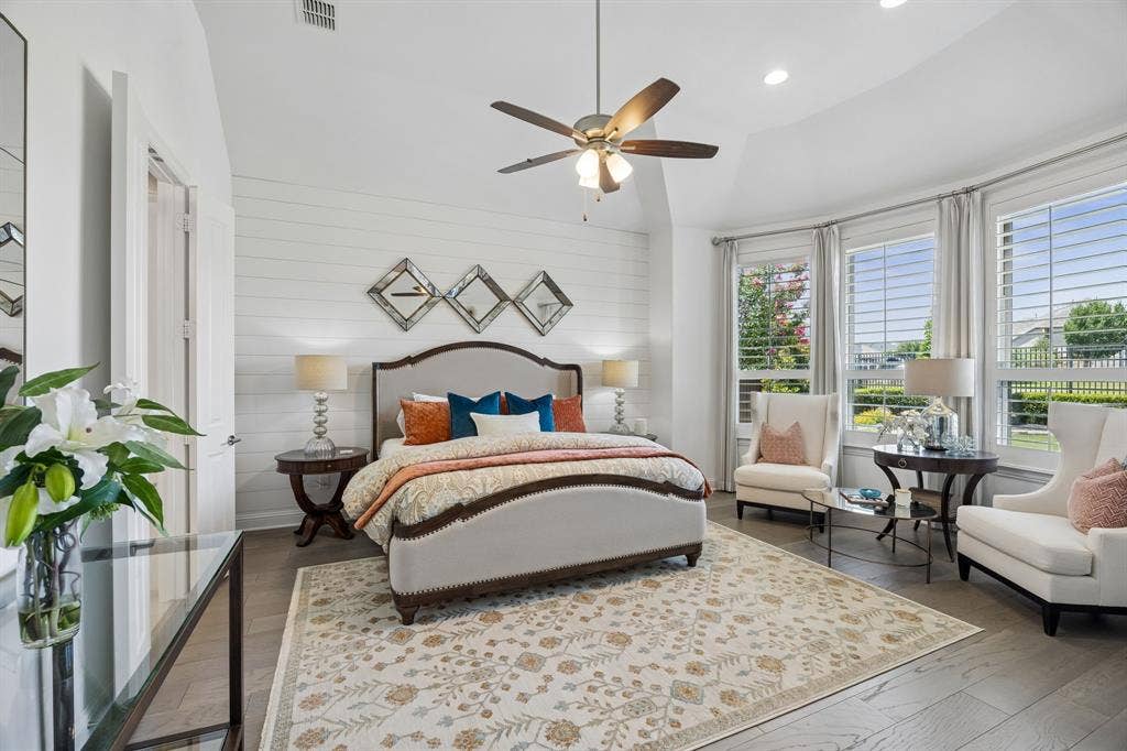 641 Country Brook Lane, Prosper, TX 75078 Large oversized primary bedroom boasts a striking wood accent wall, large bay window providing an abundance of natural light and stunning views across the lake and up the rolling hills of the greenbelt with towering trees.