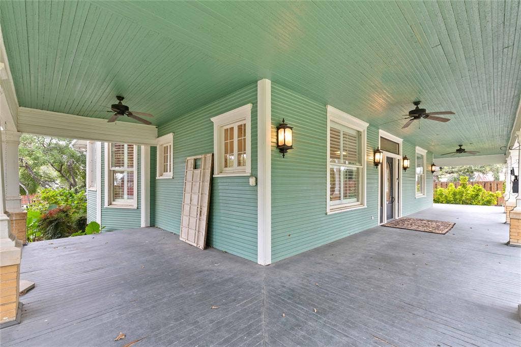 Wrap-around porch featuring lap siding, painted beadboard ceilings, recessed ceiling fans, and wall-mounted exterior lanterns