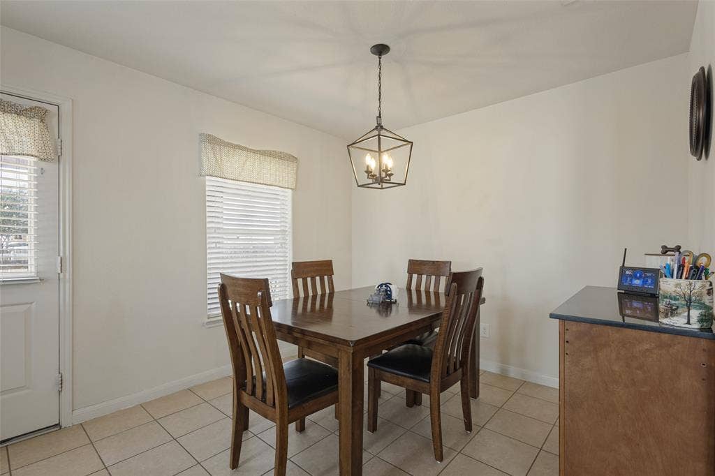 Ceramic tile flooring, industrial-style geometric pendant lighting, horizontal slat blinds, and a solid-panel entry door