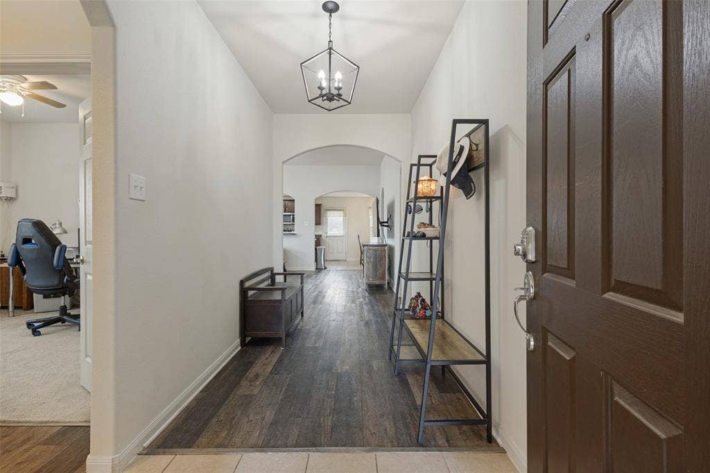 Entryway featuring wood-finish flooring, a geometric pendant light, and arched wall openings