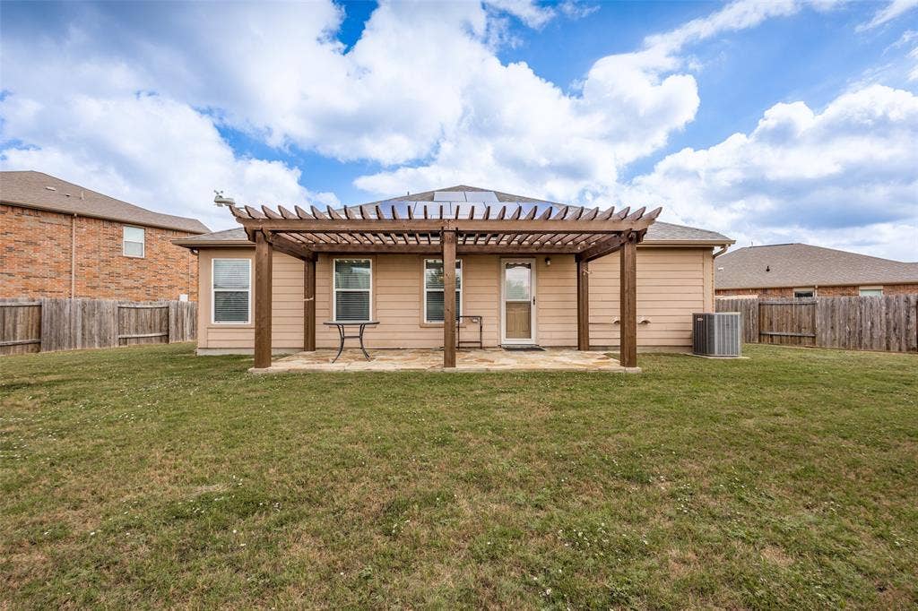 Spacious single-story residence with brick and fiber cement exterior, featuring a covered pergola-style patio extending across the rear facade
