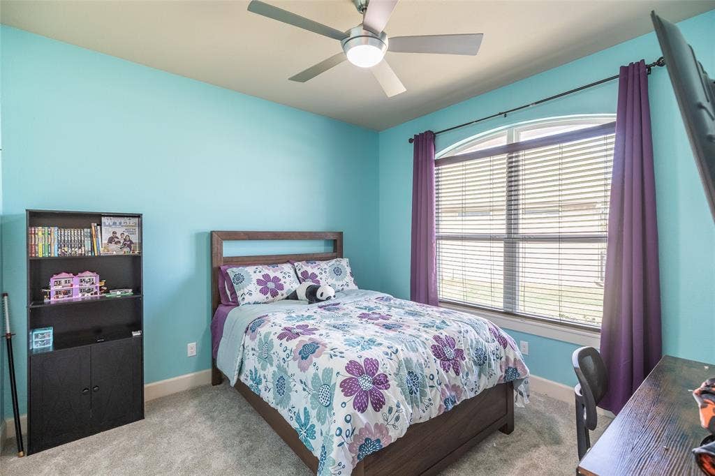 Bedroom featuring a vaulted ceiling with a brushed metal ceiling fan and light kit, neutral carpeting, and an arched window