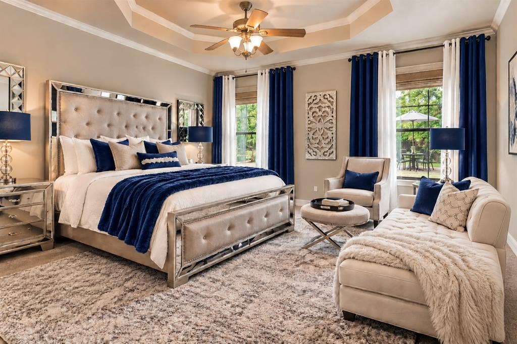 Tray ceiling with a central multi-light ceiling fan, neutral wall tones, and large windows