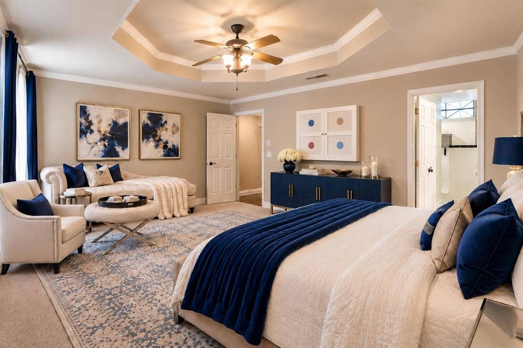 Octagonal tray ceiling featuring a central ceiling fan with integrated lighting, neutral wall palette, and crown molding