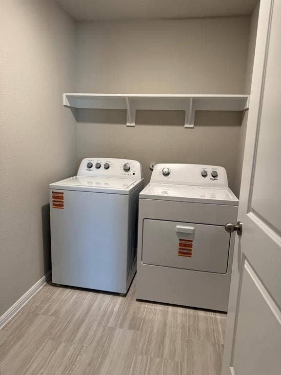 Dedicated laundry area featuring tile flooring, neutral wall paint, and a wall-mounted white storage shelf