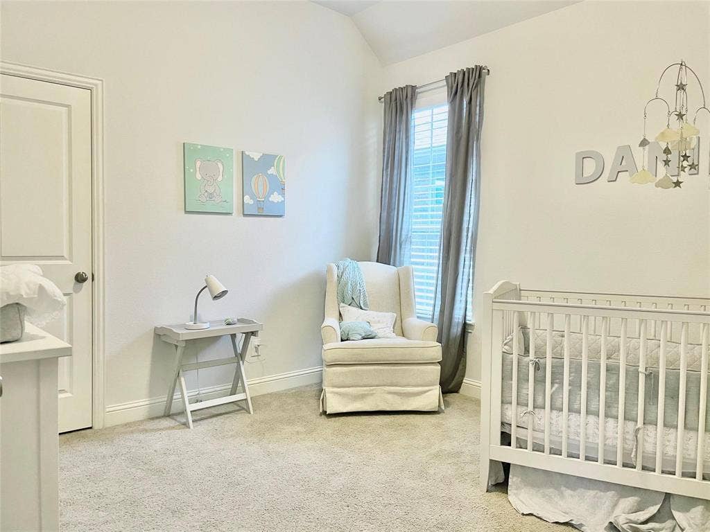 Vaulted ceilings, neutral carpeting, and a single-hung window featuring plantation-style shutters