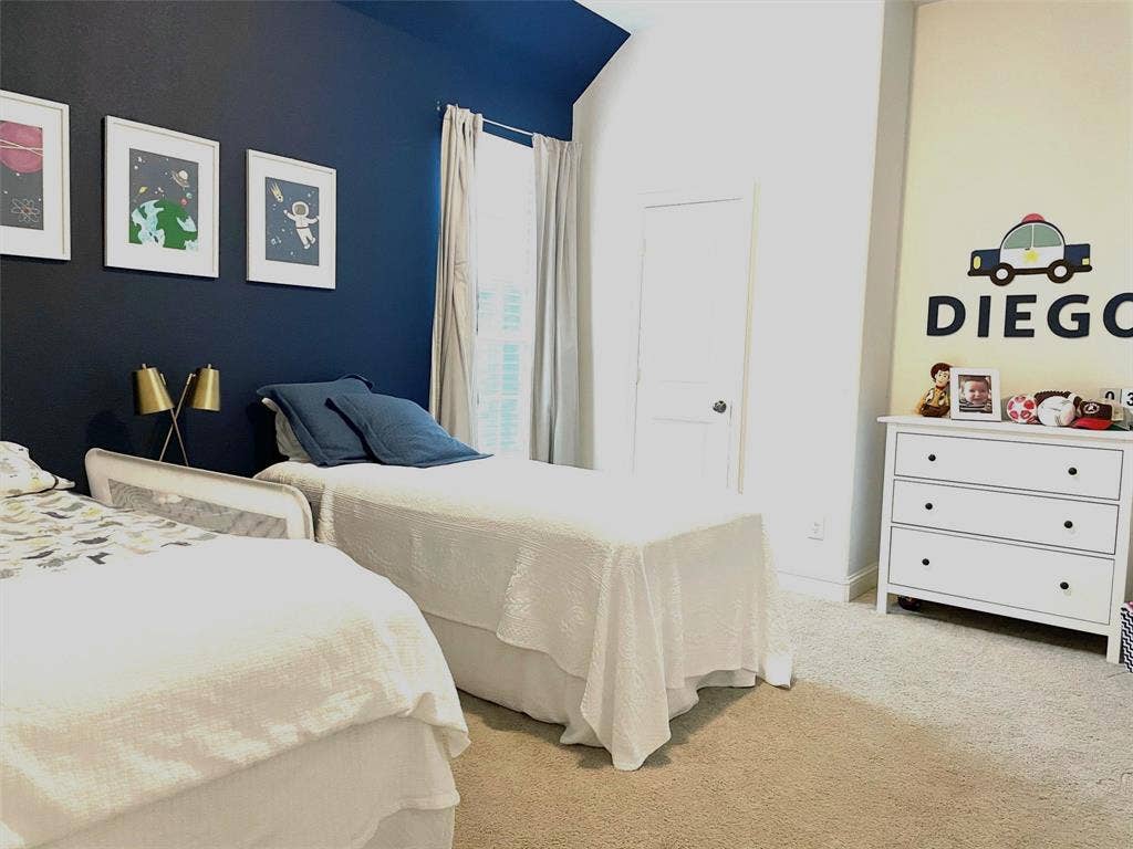 High-ceiling room featuring neutral carpeting, a dual-tone wall aesthetic, and an interior door with a silver-tone knob